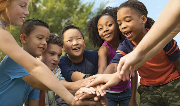 group of kids putting hands together