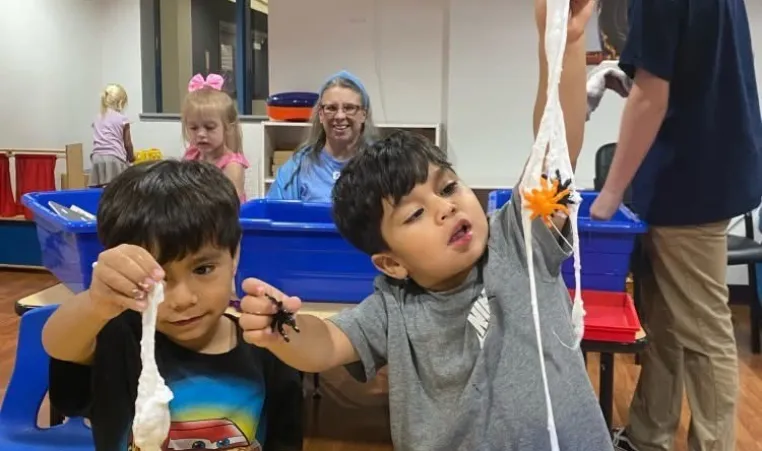 Two boys playing with stringy stuff
