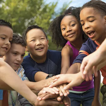 group of kids putting hands together