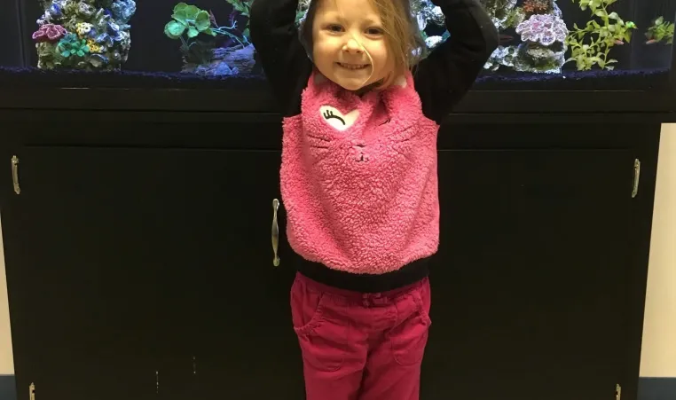 girl making a Y by fish tank