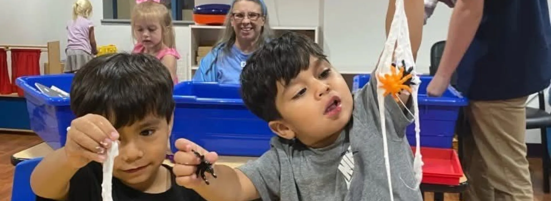 Two boys playing with stringy stuff